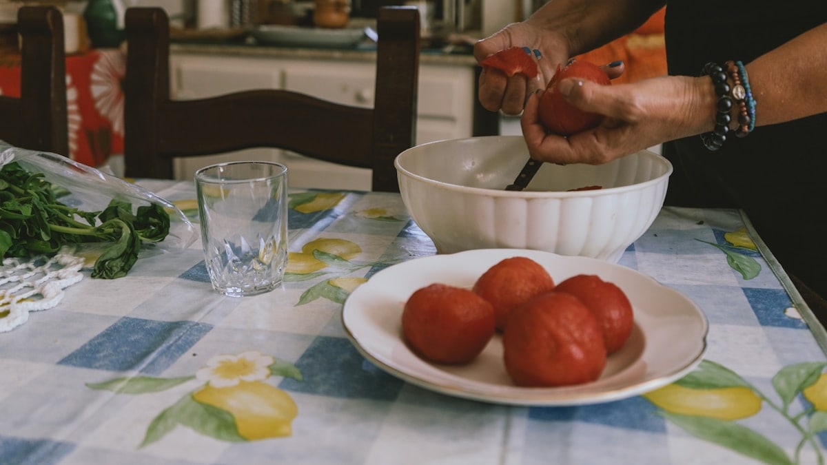 A woman is cutting tomatoes on a table