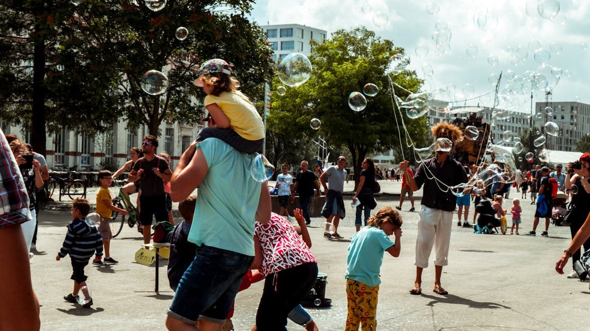 Children and adults enjoying bubbles at a street festival in Nantes, France.